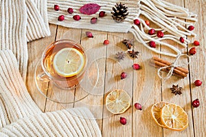 CupÃÂ ofÃÂ teaÃÂ withÃÂ lemonÃÂ onÃÂ aÃÂ woodenÃÂ tableÃÂ withÃÂ aÃÂ knittedÃÂ scarfÃÂ andÃÂ decorations